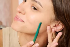 A person using the Barefaced razors to remove peach fuzz from their face