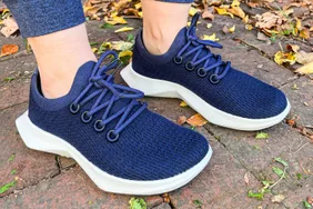 A person wears the Allbirds Women's Tree Dasher 2 Shoes outside 