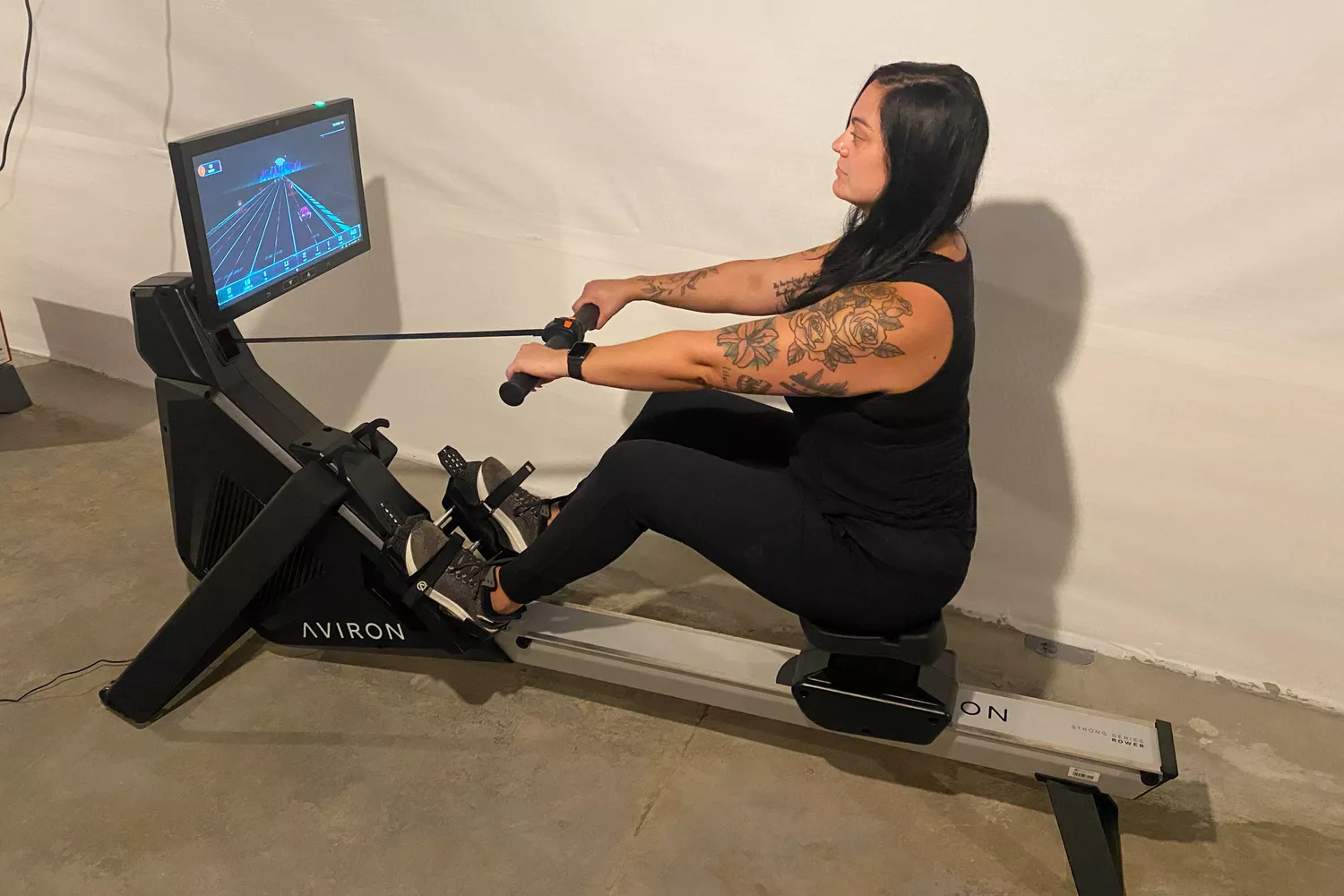 A person uses the Aviron Strong Series Rowing Machine 