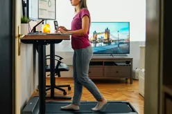 working from home at standing desk is walking on under desk treadmill