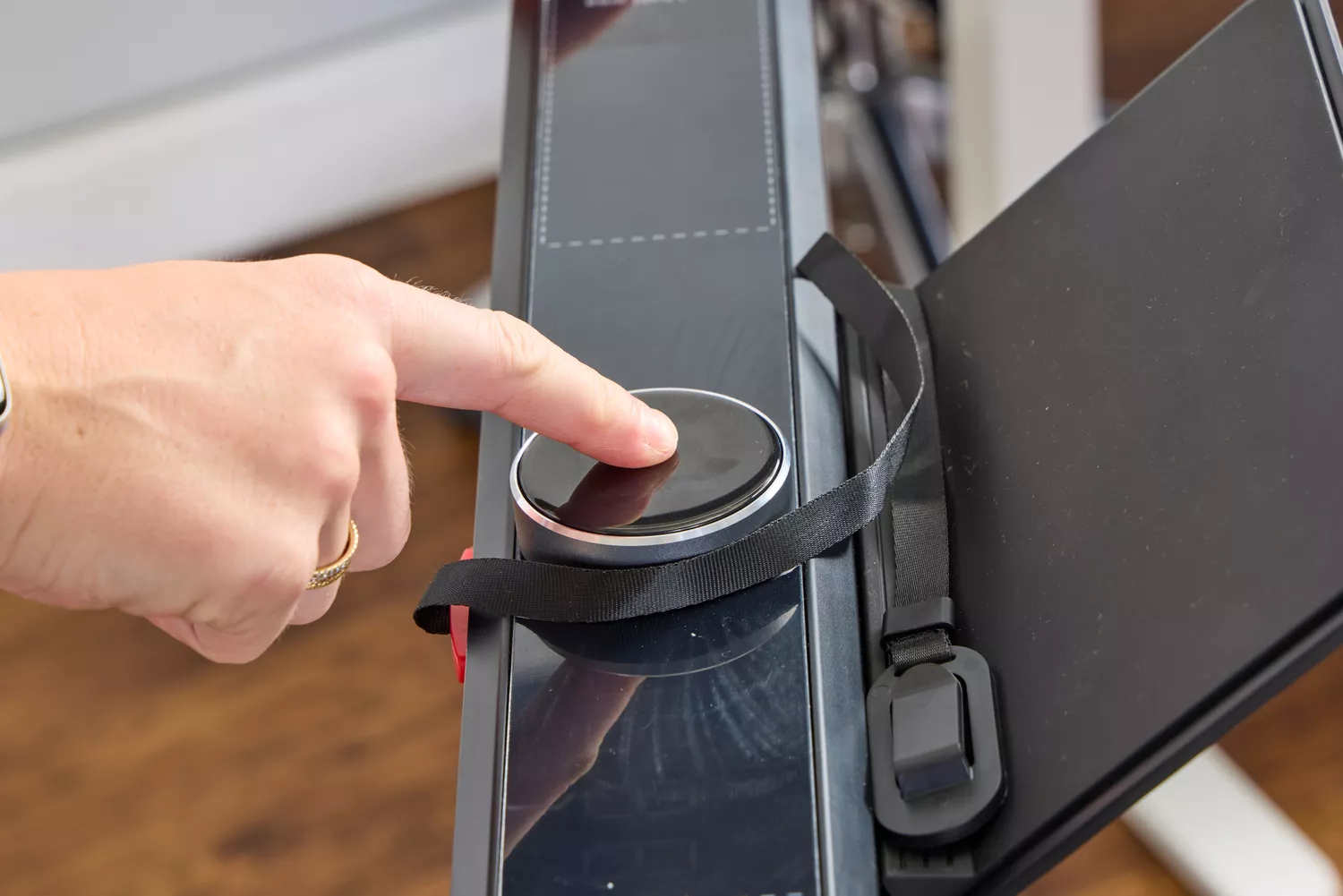 A person pressing a button on the WalkingPad X21 Double-Fold Treadmill
