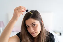 Applying Hair Serum To Her Hair