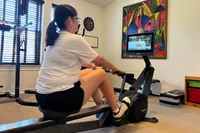A person uses the Hydrow Wave Rowing Machine