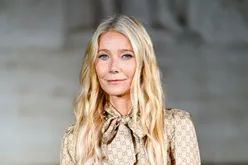 Gwyneth Paltrow smiling softly wearing a patterned blouse