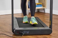 A close up of a person walking on the WalkingPad X21 Double-Fold Treadmill