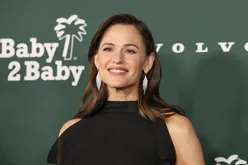 A person on a green background at the Baby2Baby event